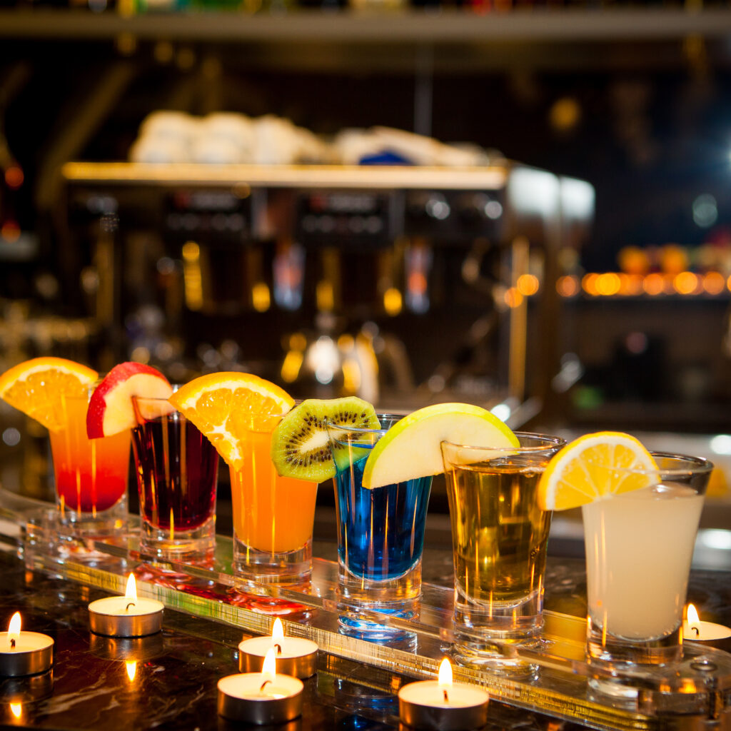 Colorful cocktail shots with fruit garnishes
